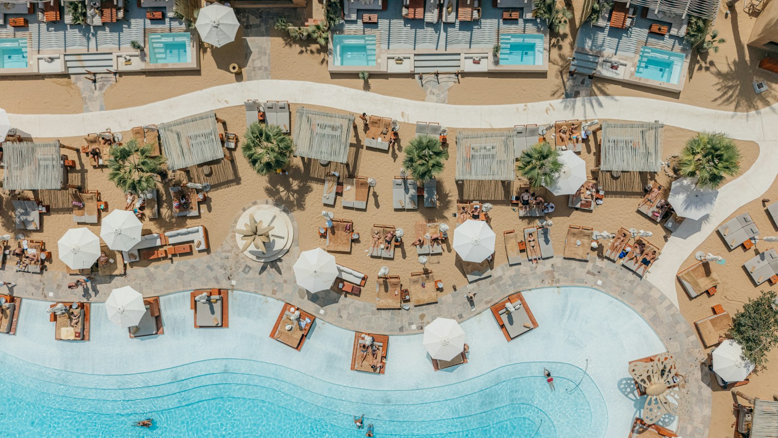 A luxury resort pool with cabanas and lounge chairs
